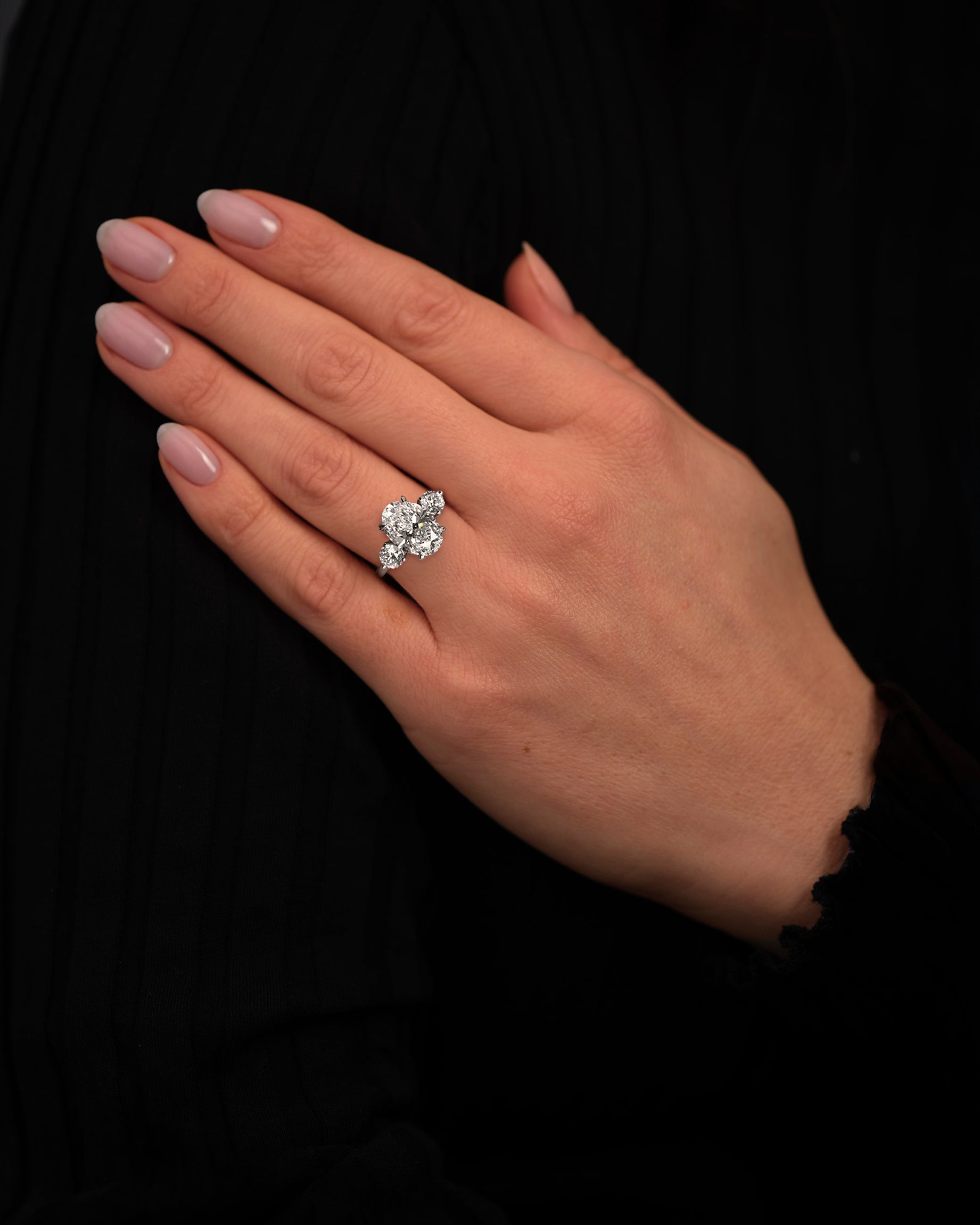 3.50ct lab grown oval cut diamond and round brilliant trilogy engagement ring on hand