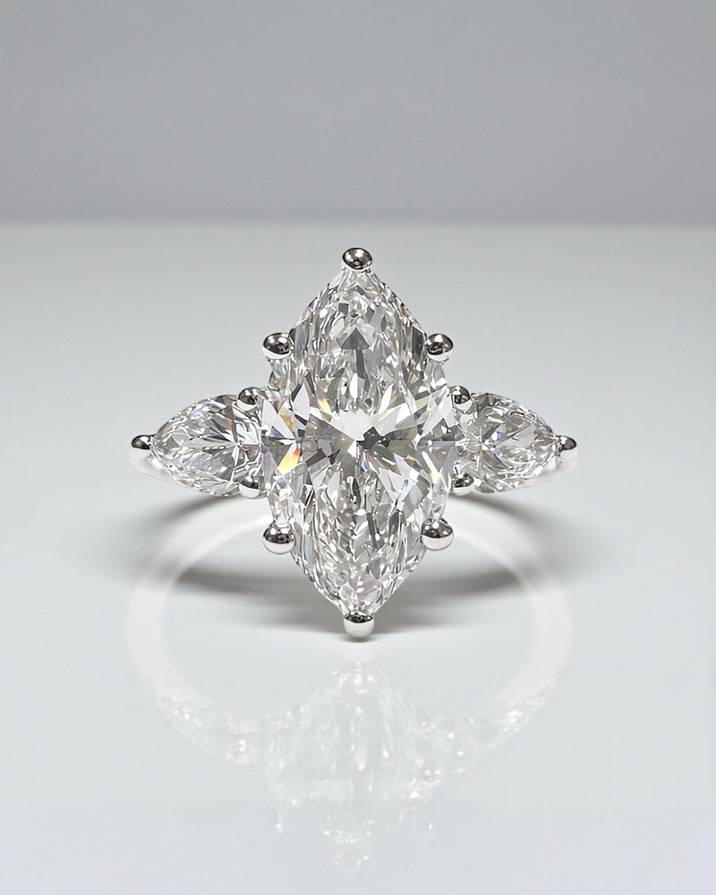 A 3ct marquise diamond trilogy ring with pear shaped side stones.