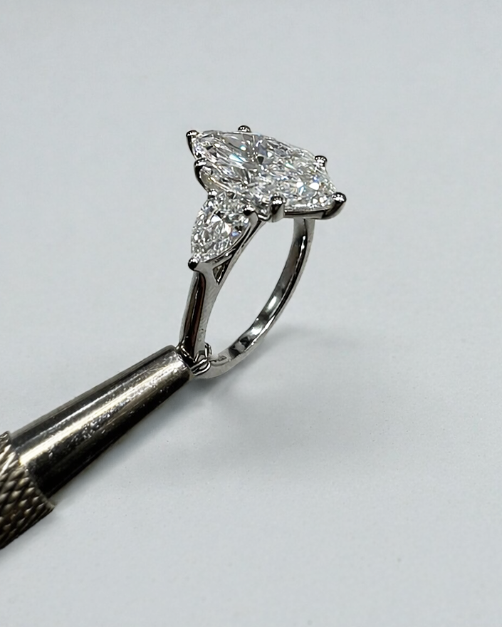 3ct marquise diamond pear trilogy ring worn on a finger.
