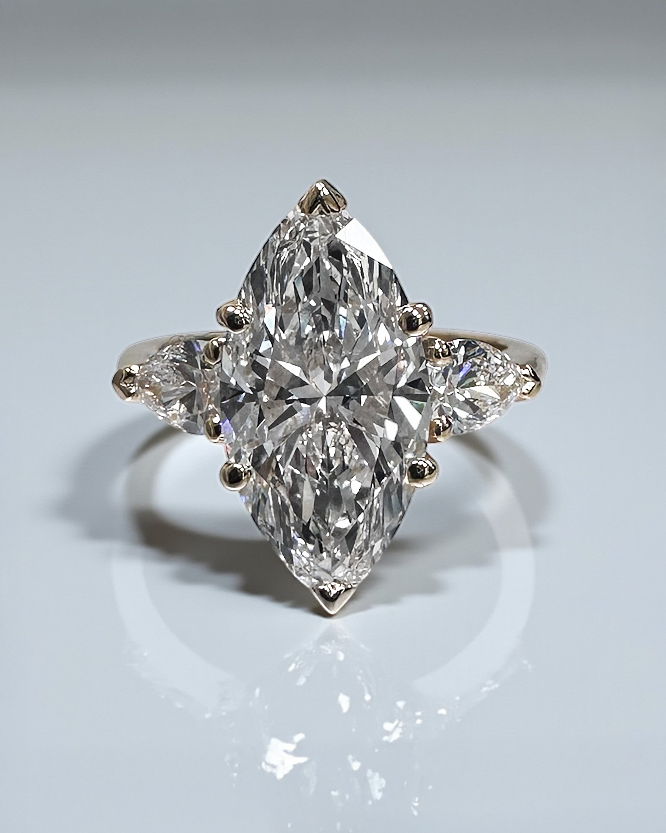 3ct marquise engagement ring diamond with pear shaped side stones in a trilogy setting.