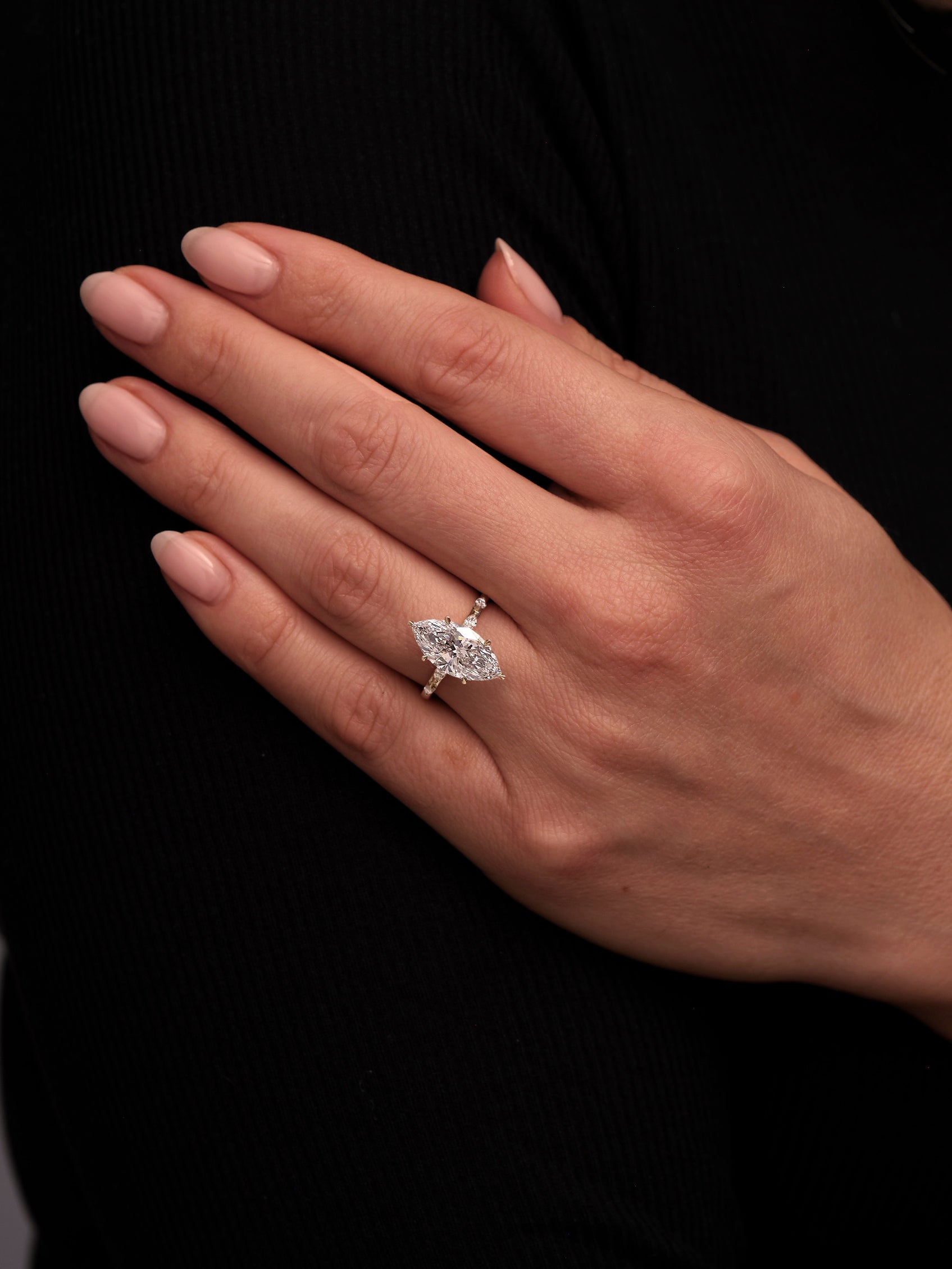A 3.50ct marquise engagement ring worn on a finger to show scale and sparkle.