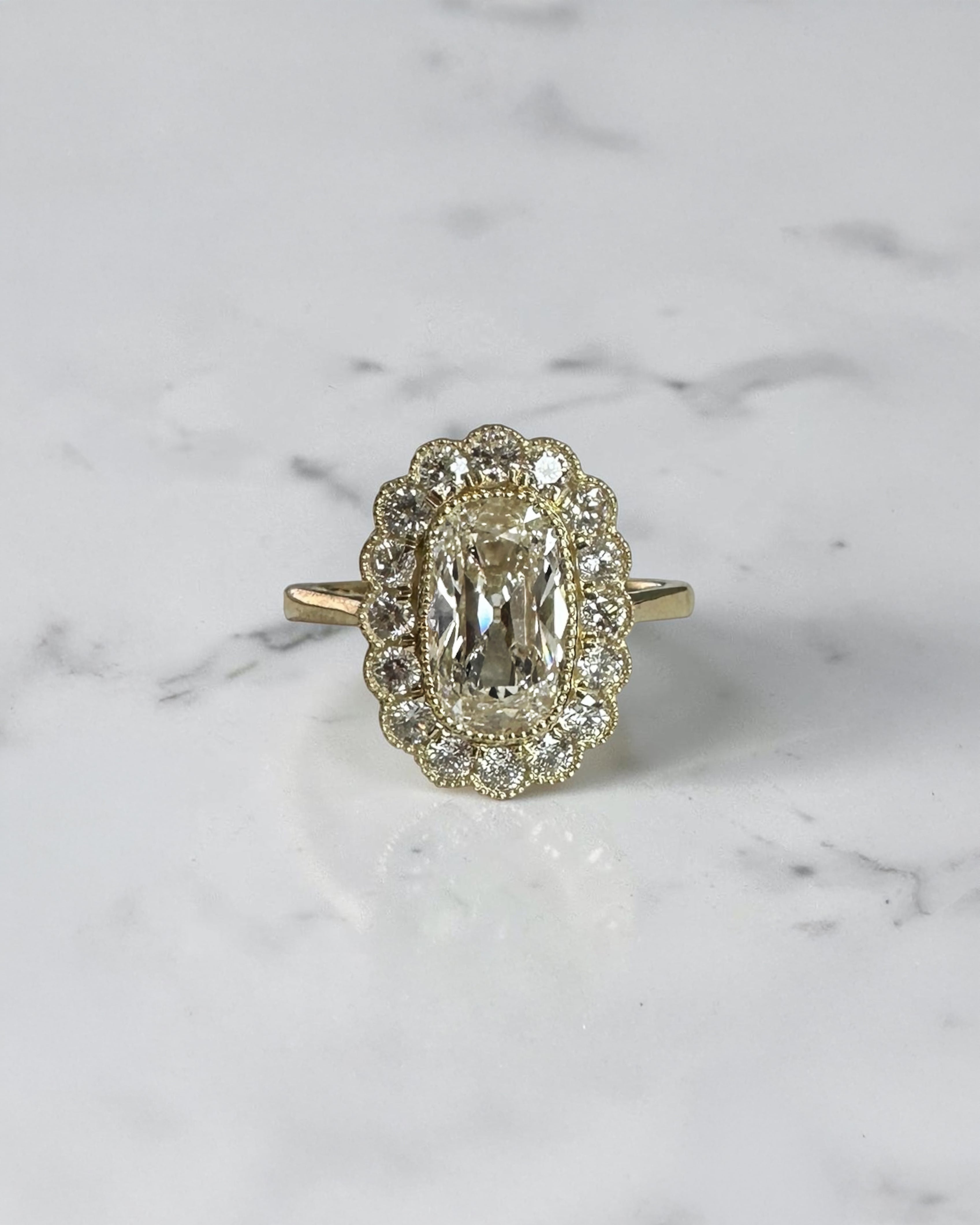 2ct elongated old mine cut cushion lab grown diamond engagement ring with bezel setting and vintage scalloped diamond halo
