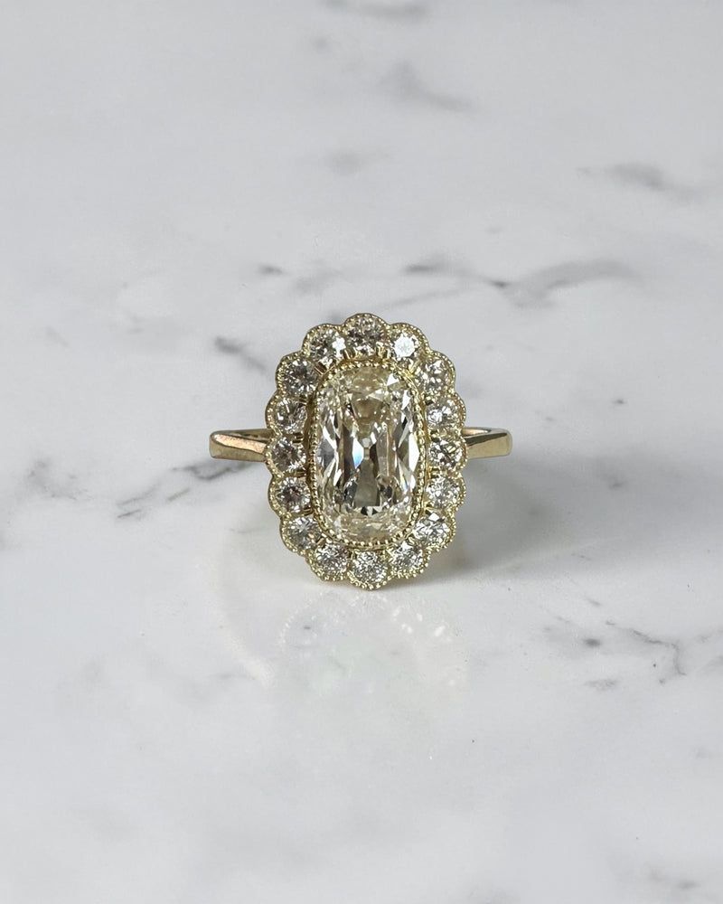 2ct elongated old mine cut cushion lab grown diamond engagement ring with bezel setting and vintage scalloped diamond halo

