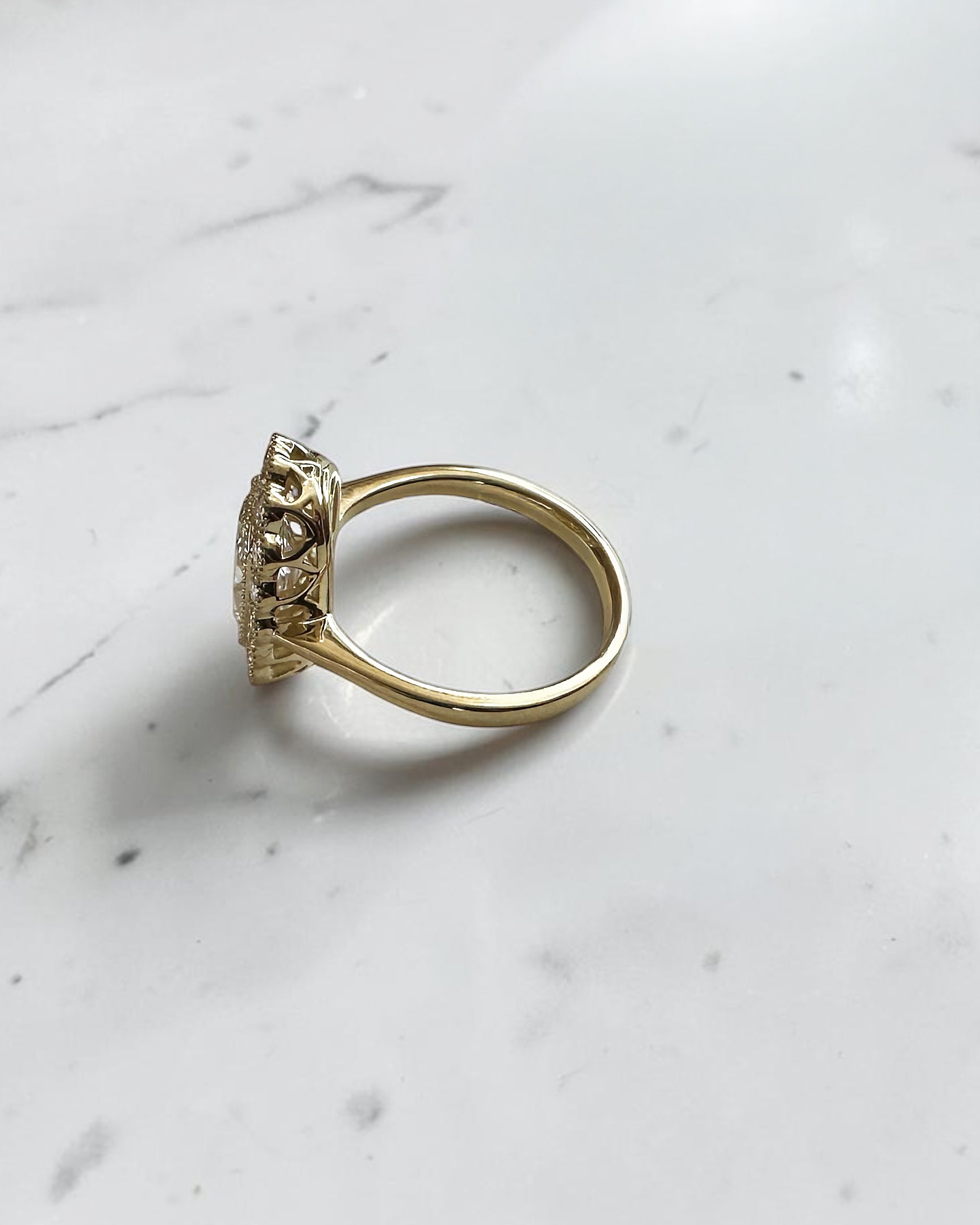 2ct elongated old mine cut cushion lab grown diamond engagement ring with bezel setting and vintage scalloped diamond halo
