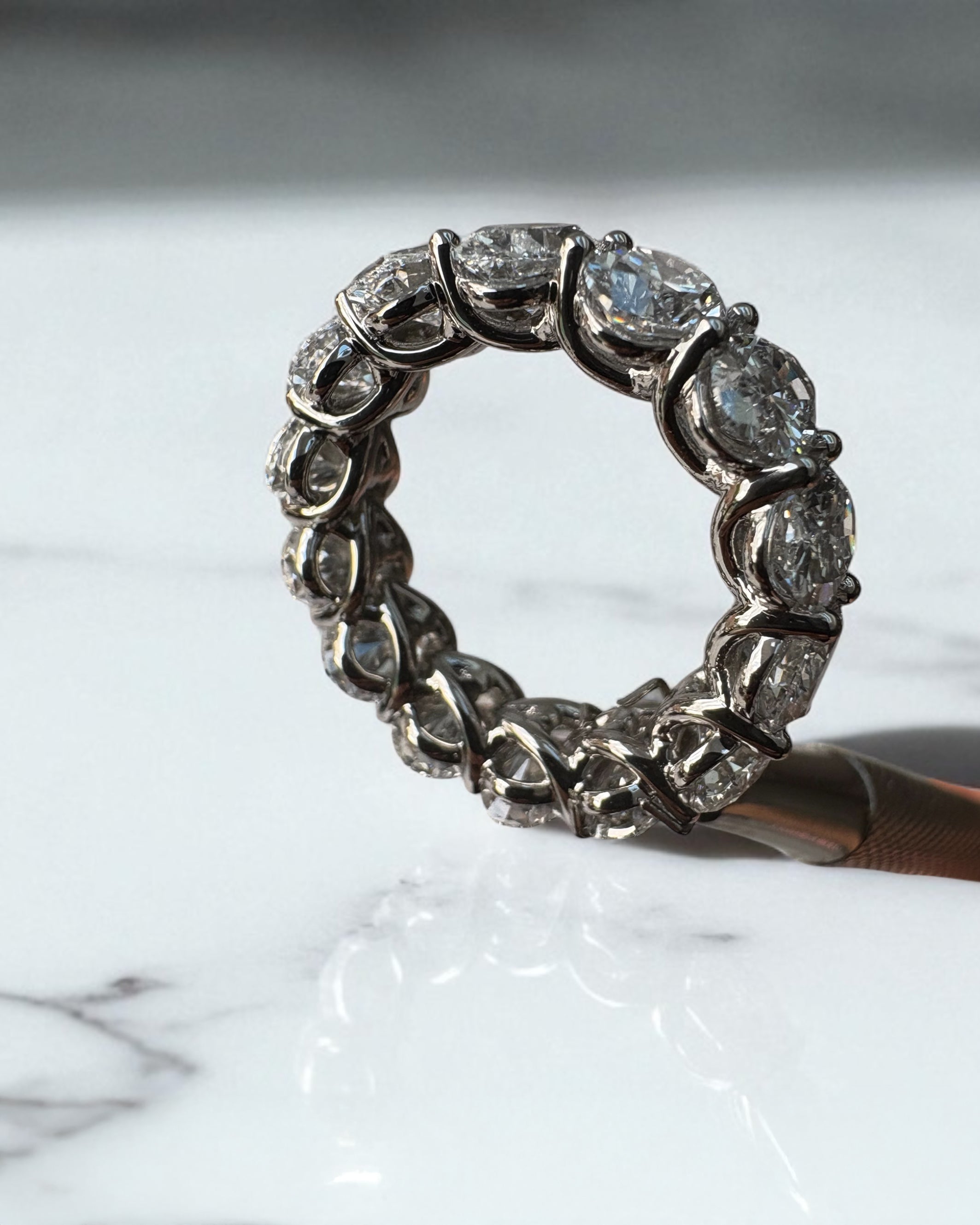 10ct full oval diamond eternity band worn on a finger, showcasing a statement oval diamond engagement rings design.