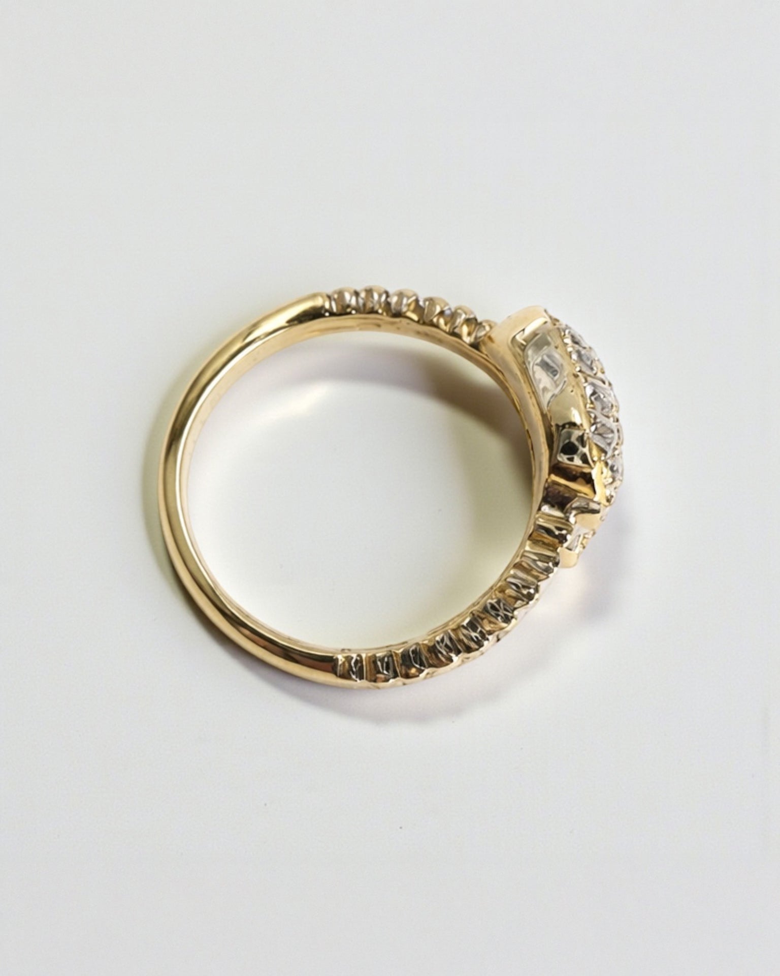 Side view of serpent wrap diamond ring showing ribbed gold band and pear shaped diamond pavé ends, 9ct gold.