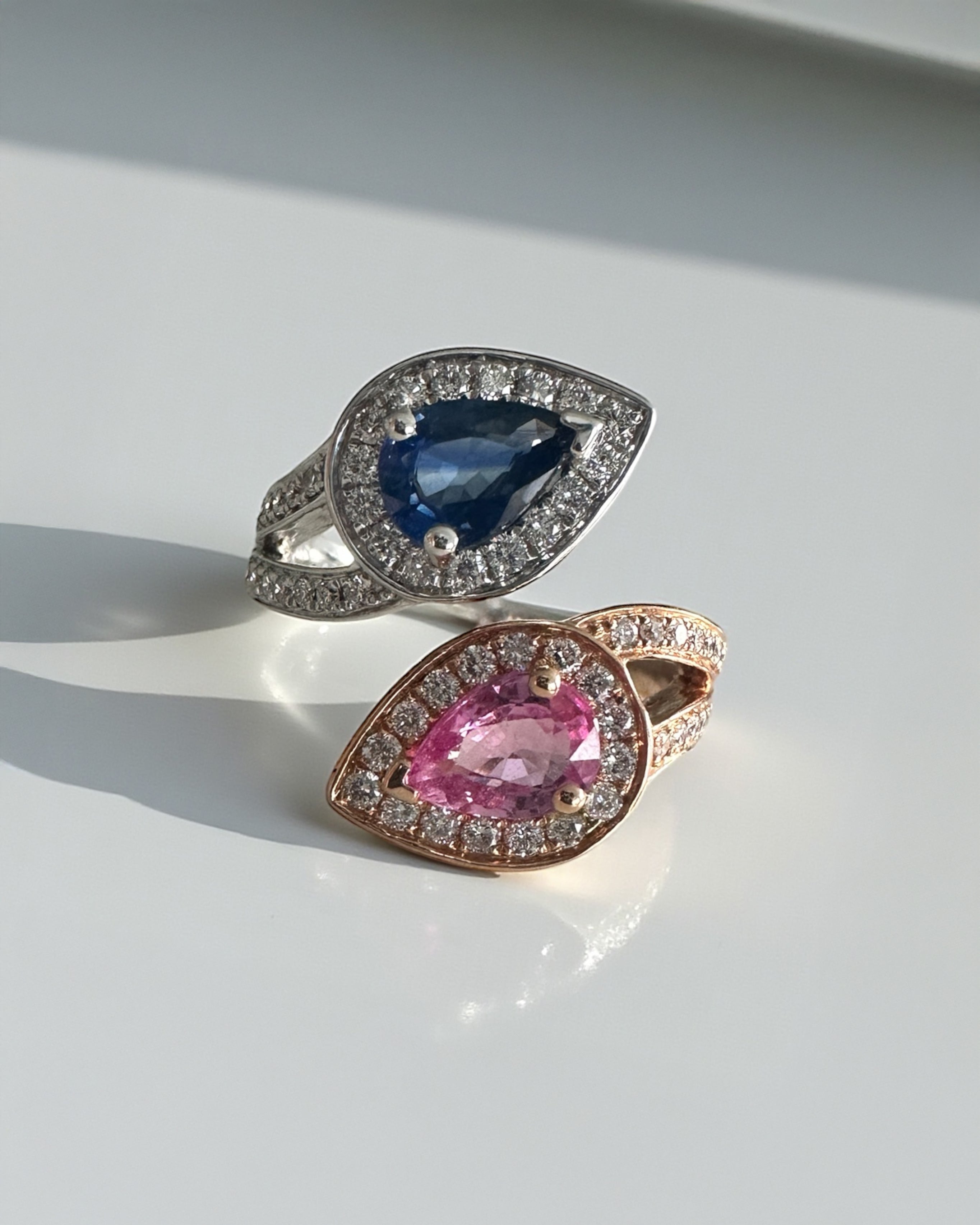 Pink and blue pear cut sapphire two stone ring with diamond halos in 18ct rose and white gold 
