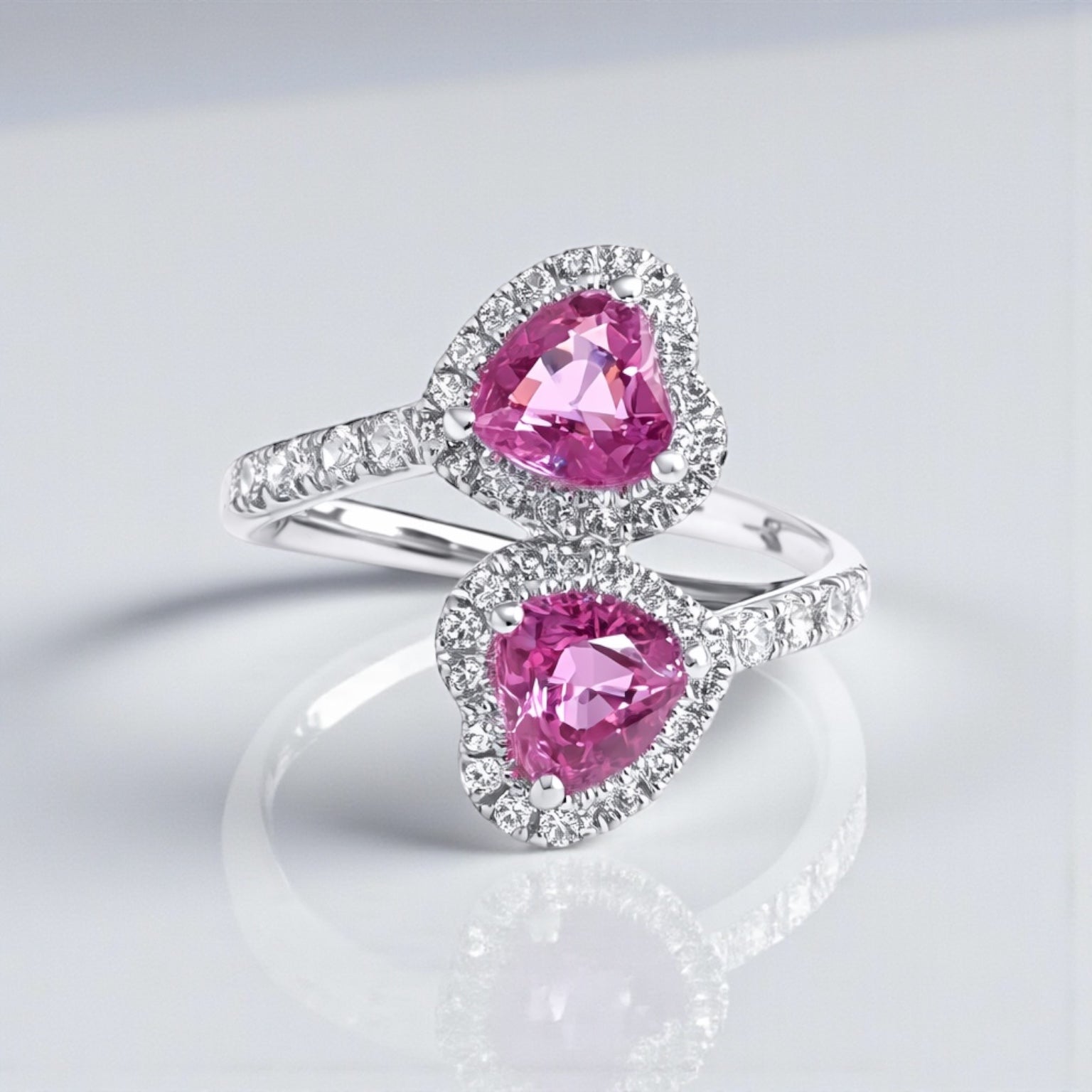 Two stone heart cut pink sapphire and diamond halo ring in platinum