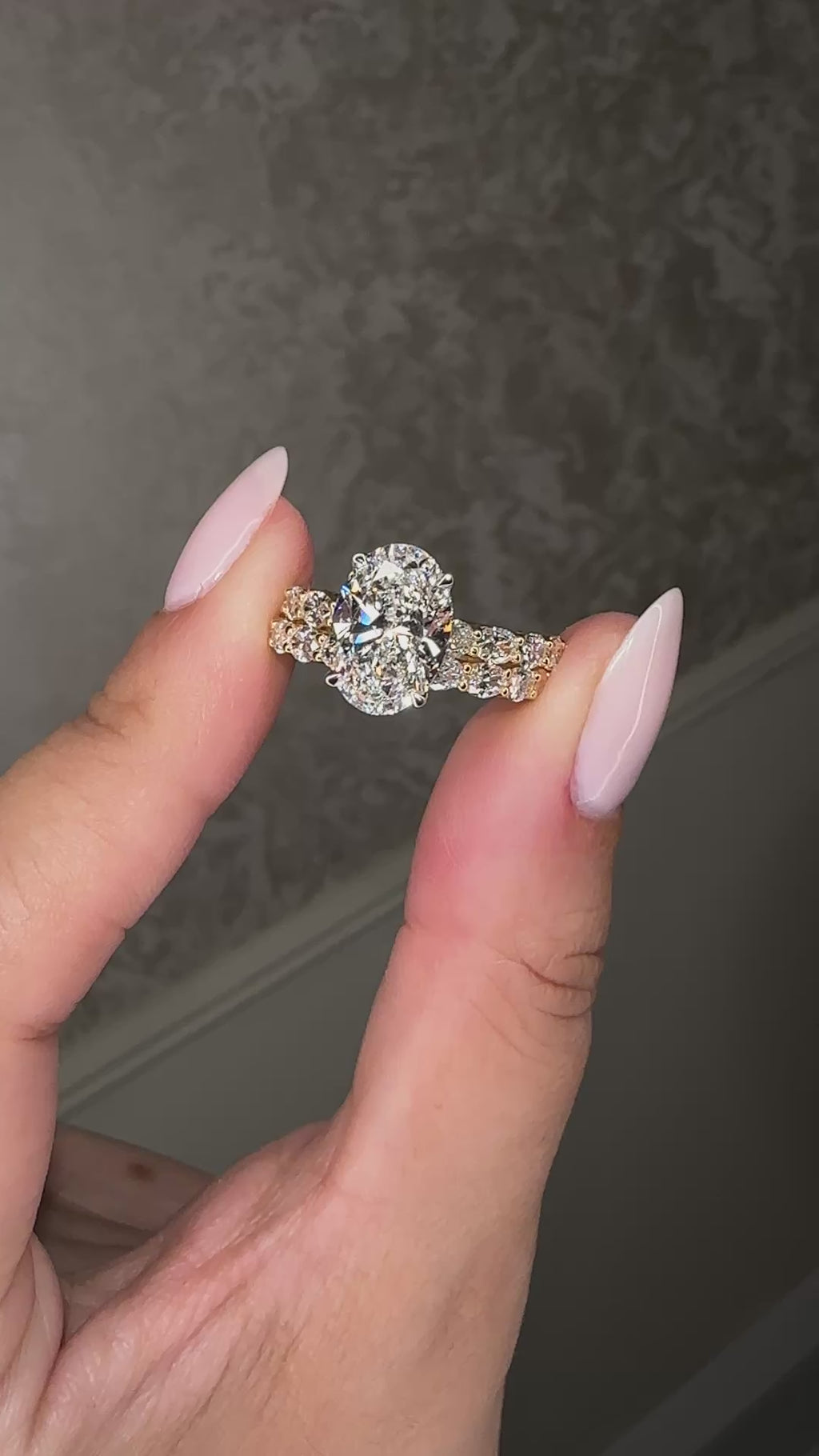 3ct oval cut lab grown diamond hidden halo engagement ring with east west oval diamond band in two tone platinum and 18kt yellow gold.