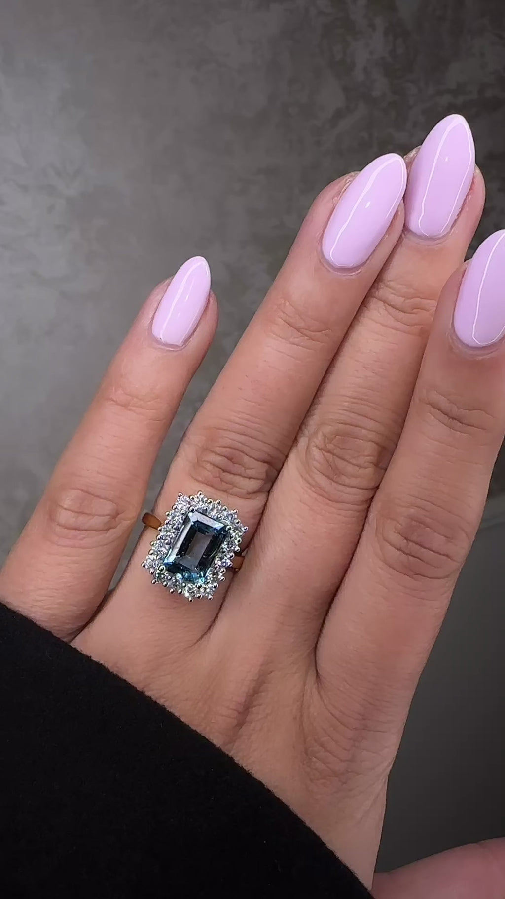 Emerald cut aquamarine and diamond halo ring in 18kt yellow gold with platinum basket on hand
