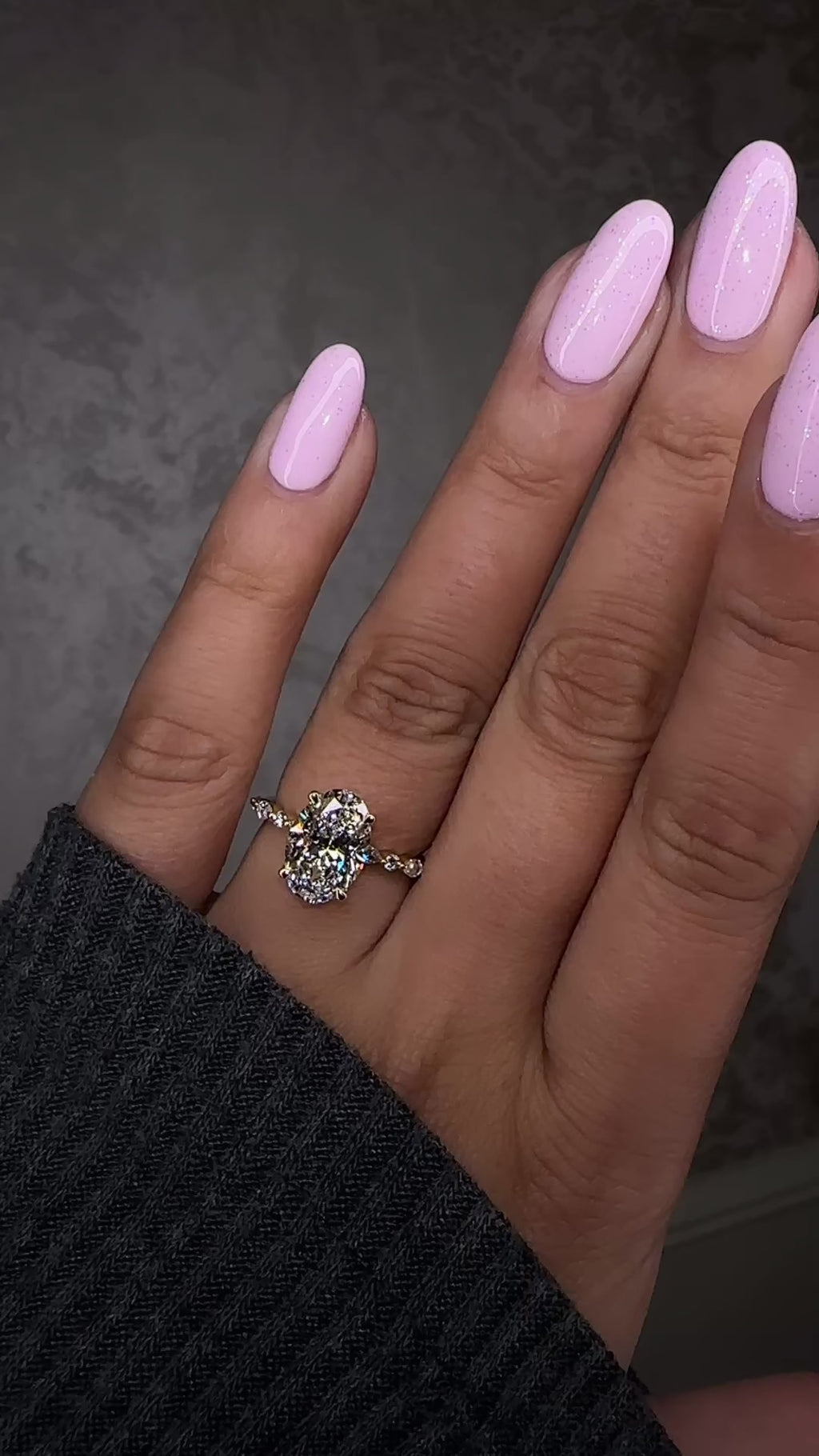 Oval 3ct lab grown diamond ring featuring marquise and round diamond band and delicate hidden halo 18kt yellow gold on hand