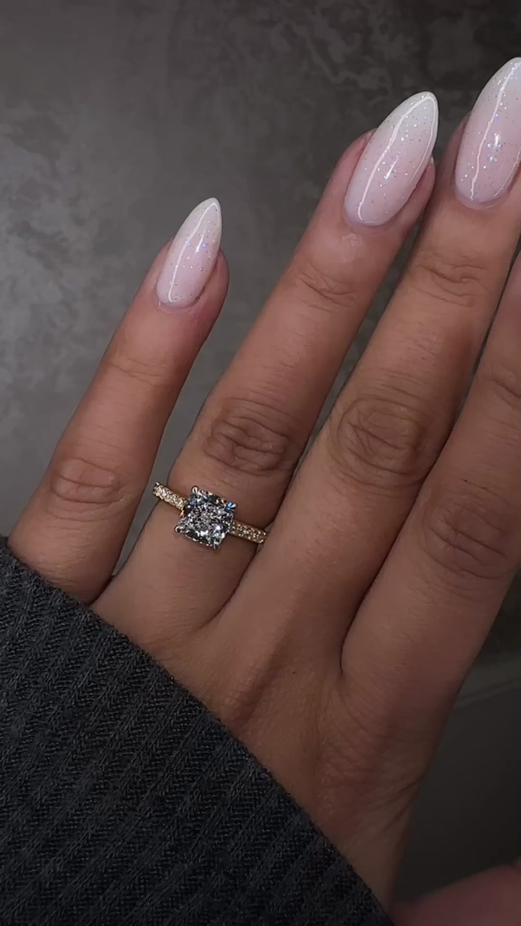 Two tone cushion cut diamond engagement ring on hand, featuring platinum head and channel set band 18kt yellow gold by Layla Diamonds