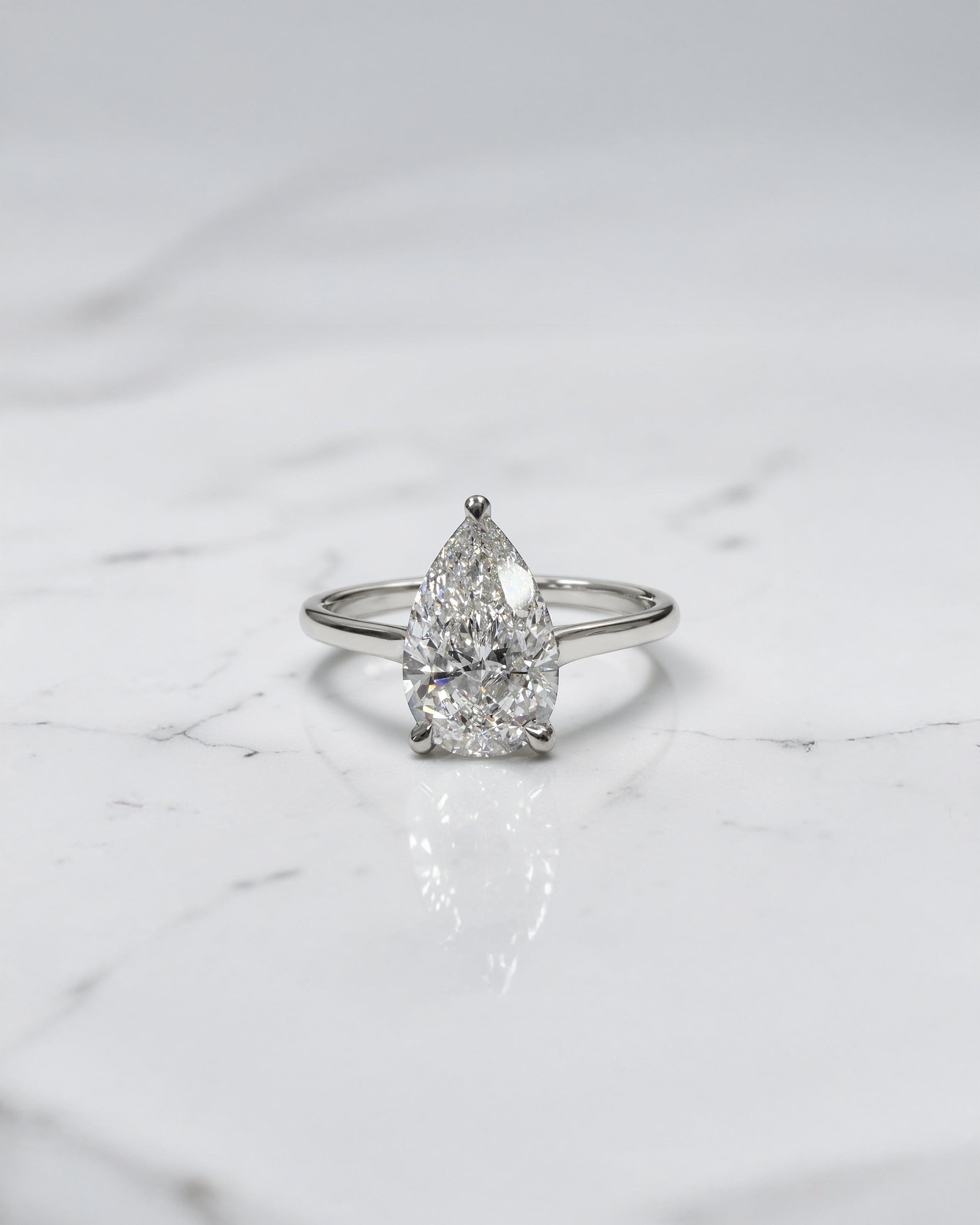 2ct pear cut lab grown diamond cathedral solitaire engagement ring with a plain band in platinum or 18kt gold, elegant and timeless design