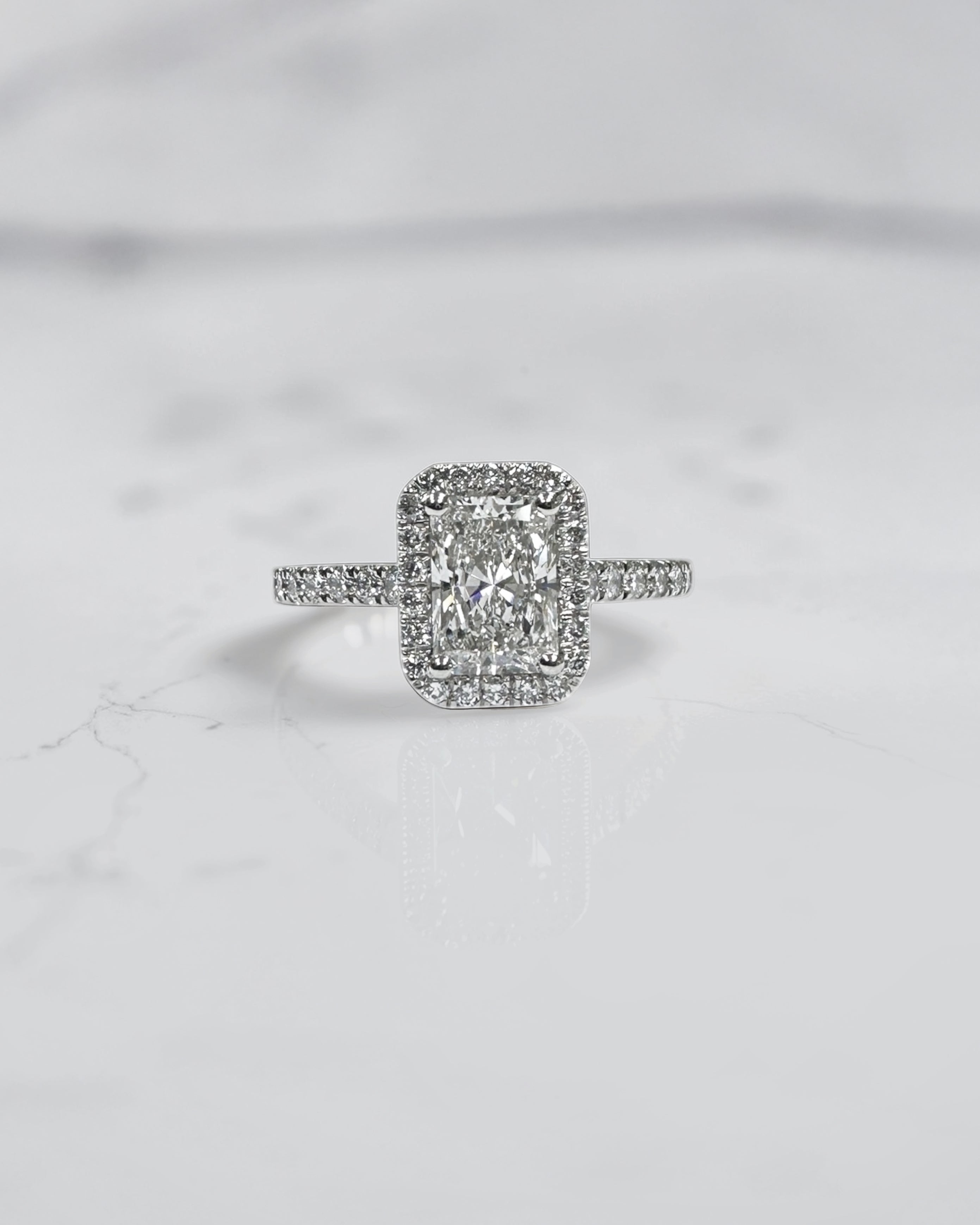 Lab grown 0.70ct radiant cut diamond halo engagement ring with seamless halo and diamond shoulders in white gold or platinum cathedral setting