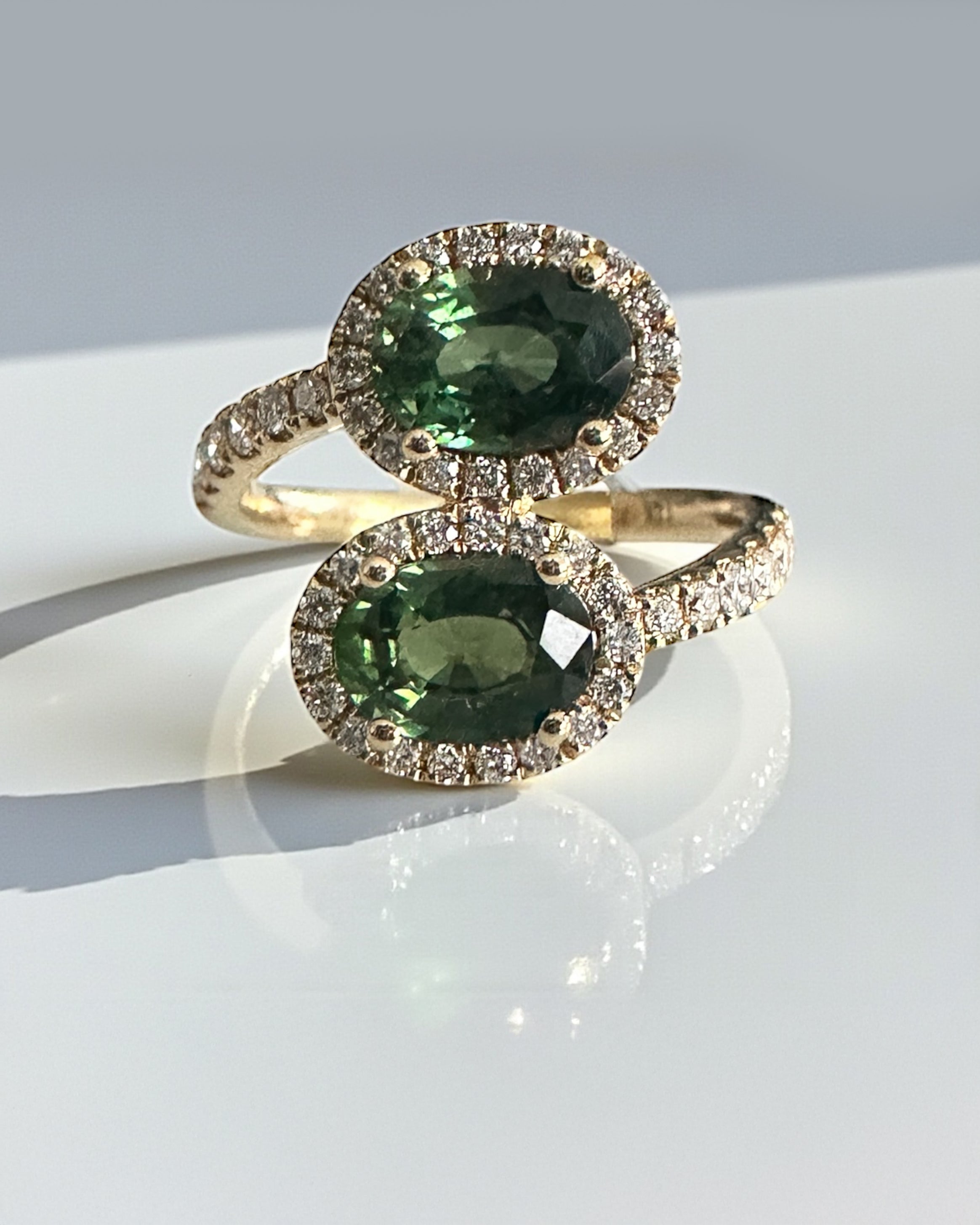 Natural teal sapphire two stone diamond halo ring in 18kt yellow gold