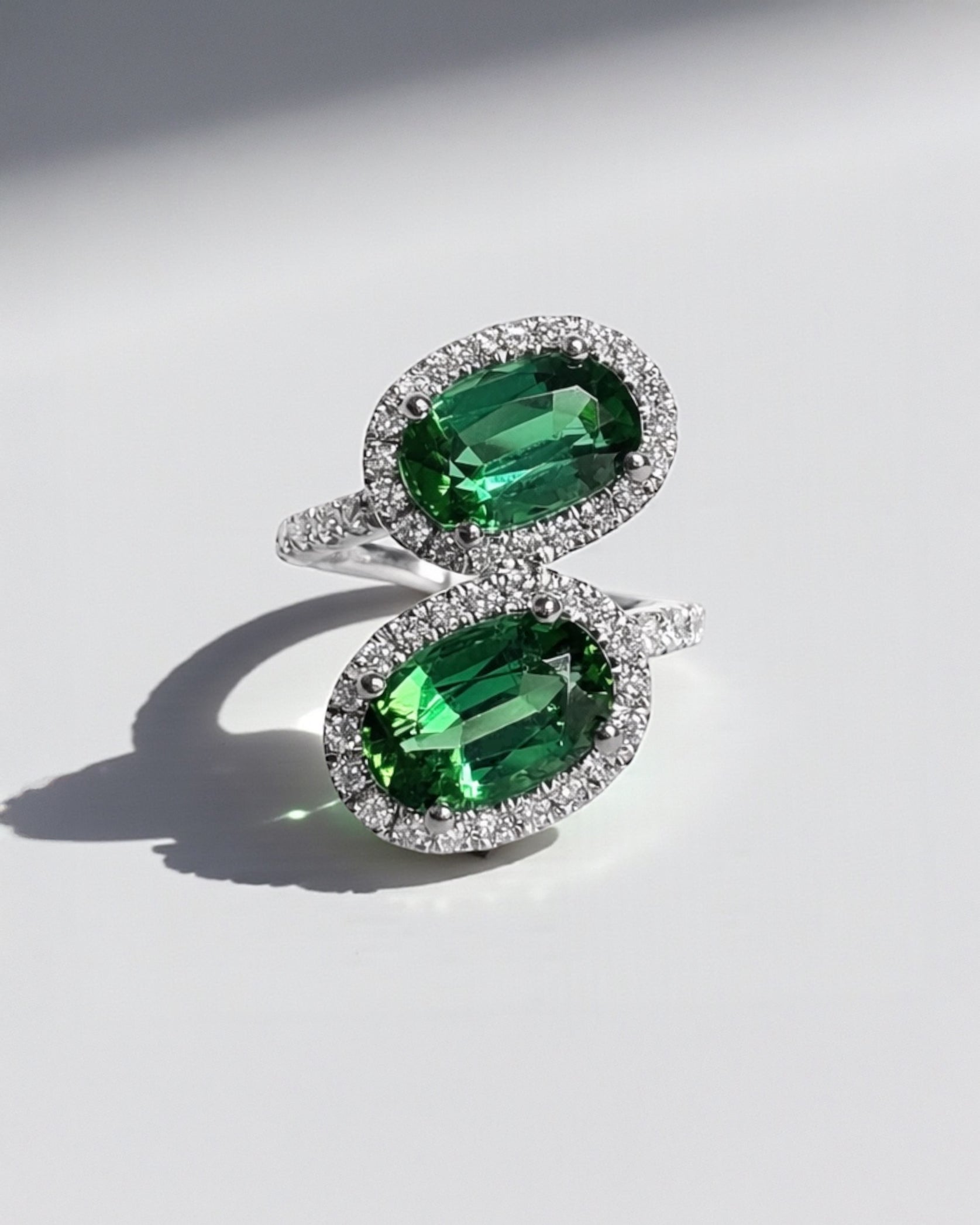 Two stone oval green tourmaline and diamond halo ring in platinum