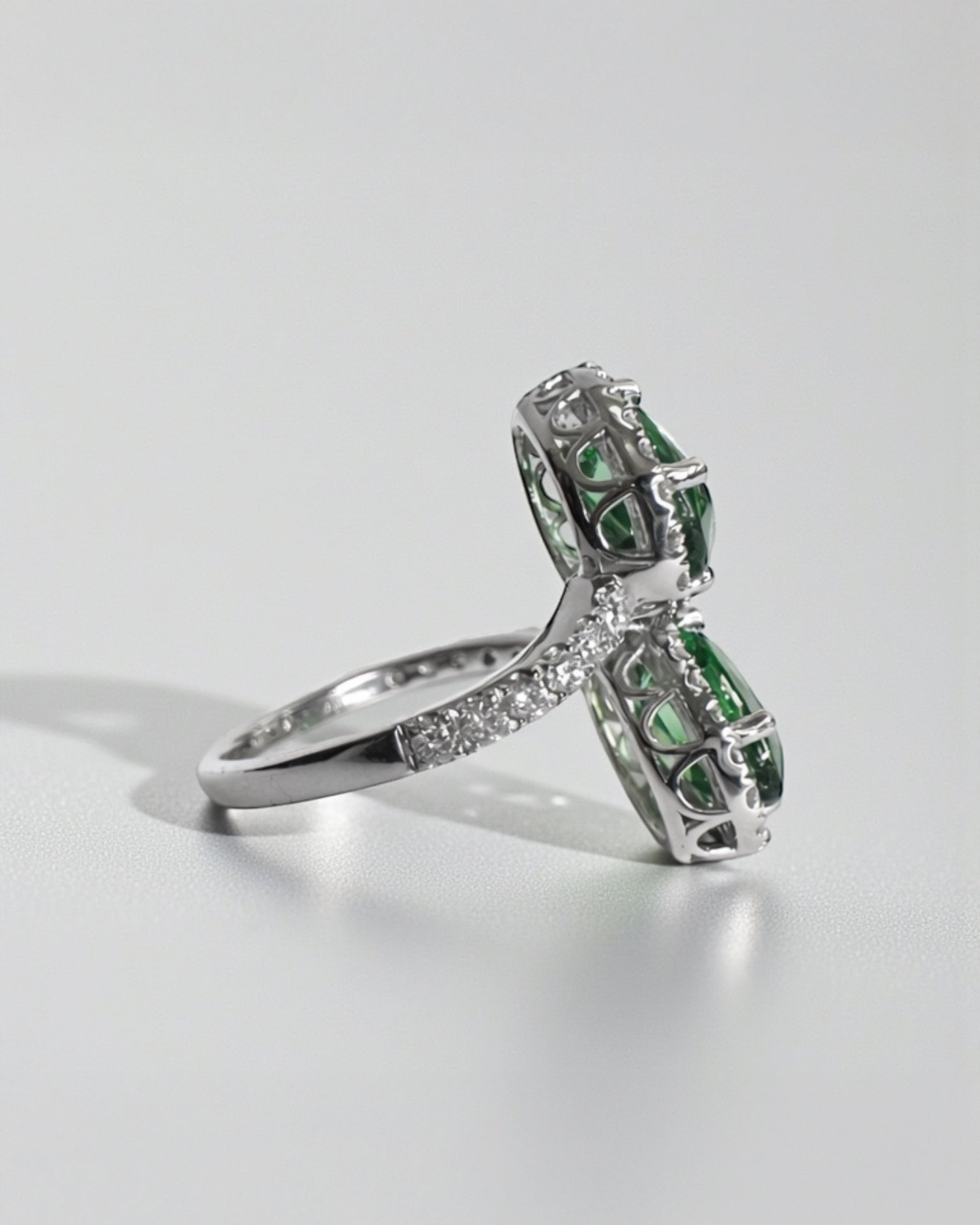 Two stone oval green tourmaline and diamond halo ring in platinum