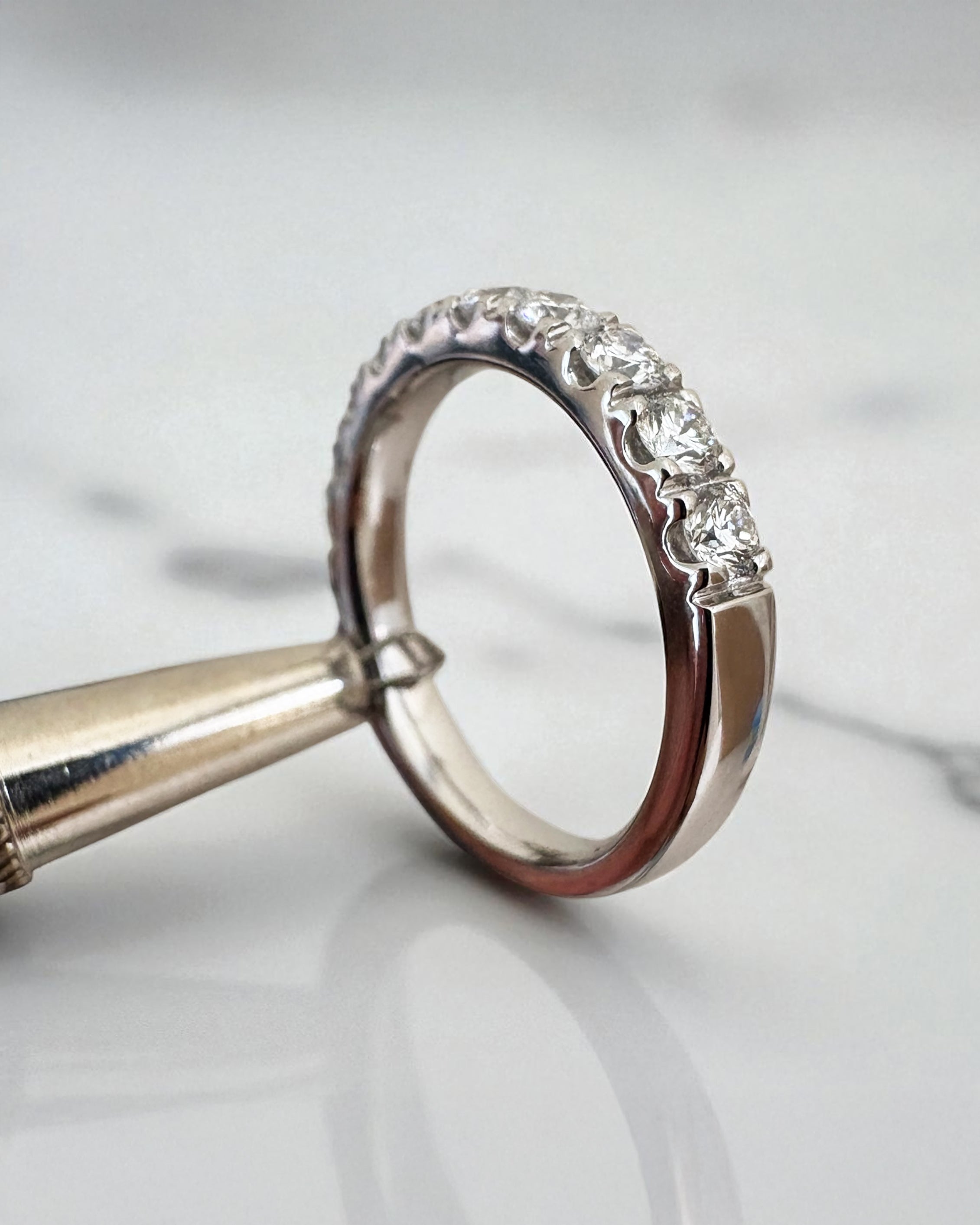 3mm half diamond eternity band worn on a finger, showcasing a timeless wedding bands for women design.