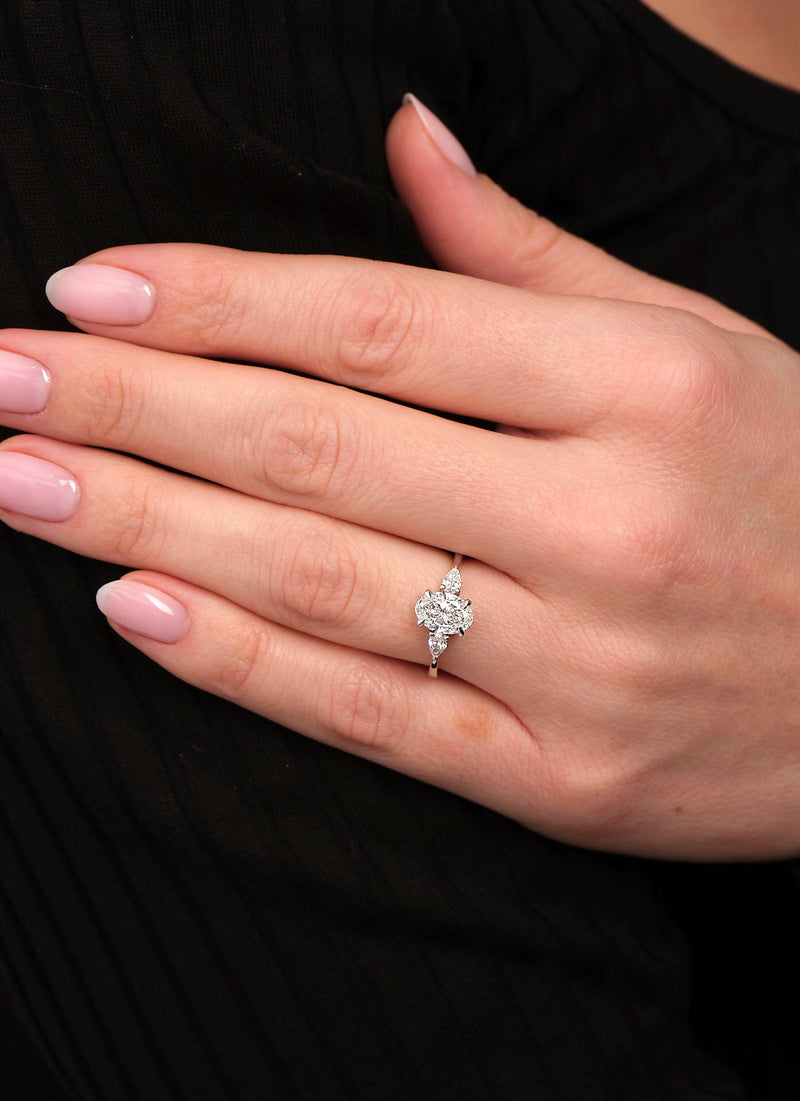 1.25ct oval cut lab grown diamond trilogy engagement ring on hand with pear cut side diamonds by Layla Diamonds.
