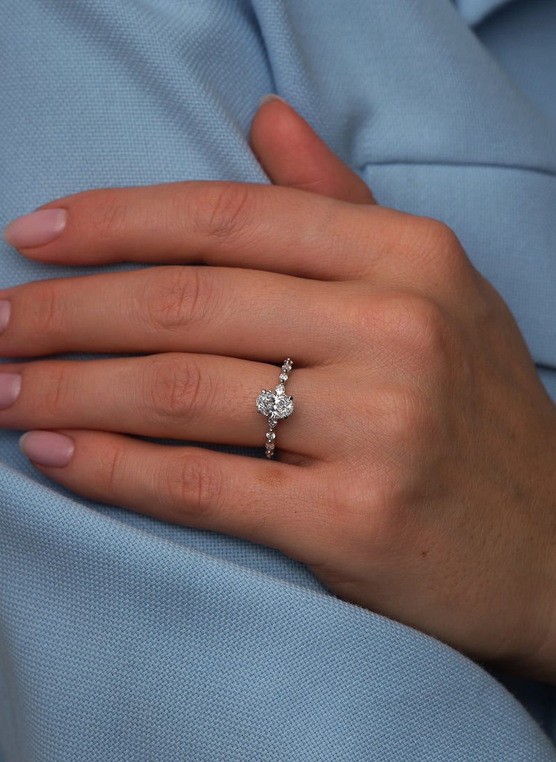 1ct oval cut lab grown diamond engagement ring on hand with marquise and round diamond band by Layla Diamonds.