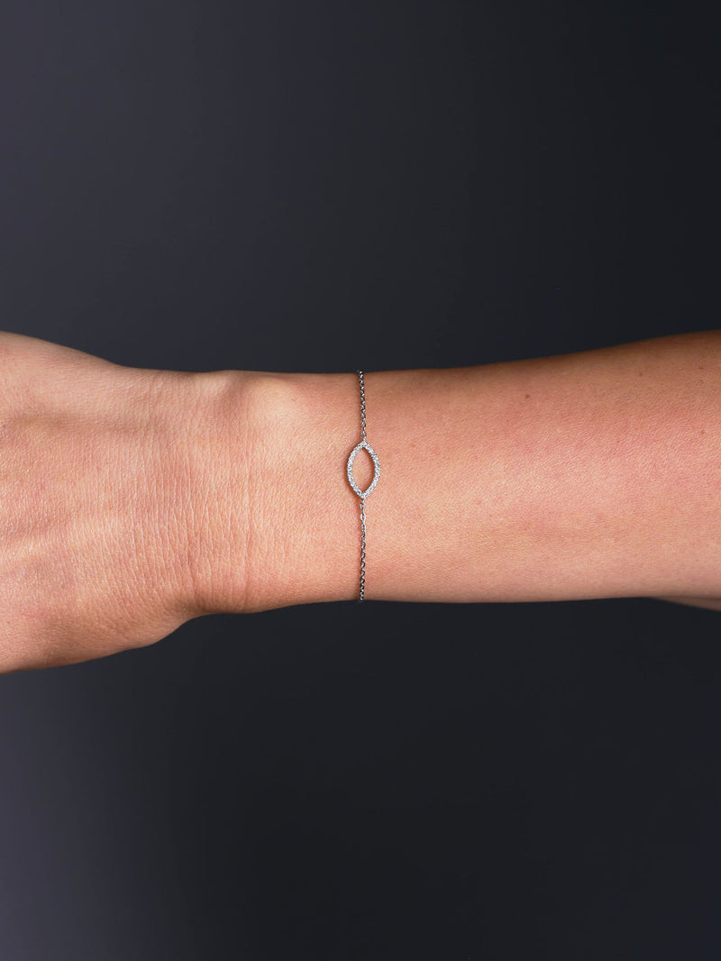 Minimalist Marquise Diamond Bracelet in yellow gold featuring a single marquise-shaped diamond motif on a fine adjustable chain, photographed on wrist, arm, hand