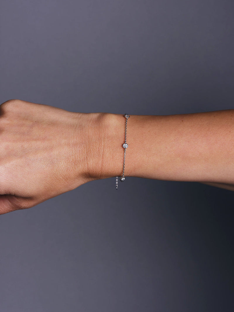 Diamond by the Yard Rubover Chain Bracelet in yellow gold featuring round brilliant diamonds bezel set along a fine adjustable chain, photographed on wrist, hand , arm