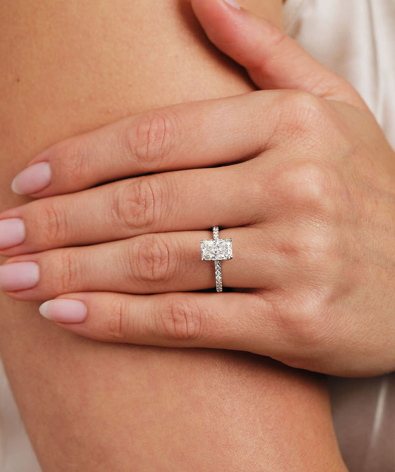 1.80ct radiant cut lab grown diamond engagement ring on hand with diamond shoulder band and wrap around hidden halo in platinum, handmade in London by Layla Diamonds.