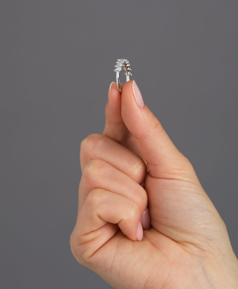 Slanted pear cut diamond band worn on a finger, showcasing a contemporary diamond rings for women design.