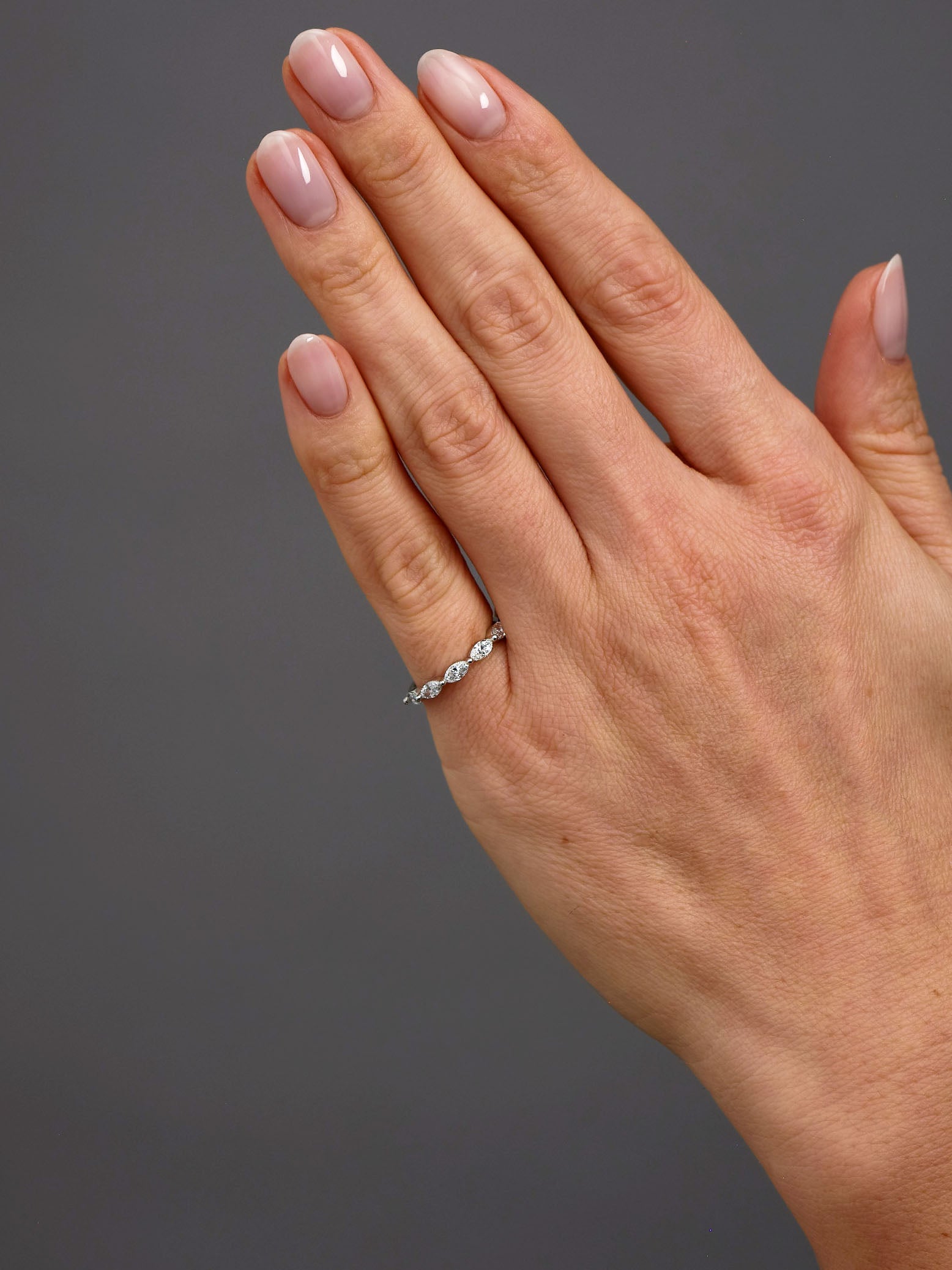 Marquise diamond engagement bands worn on a finger to showcase scale and brilliance.