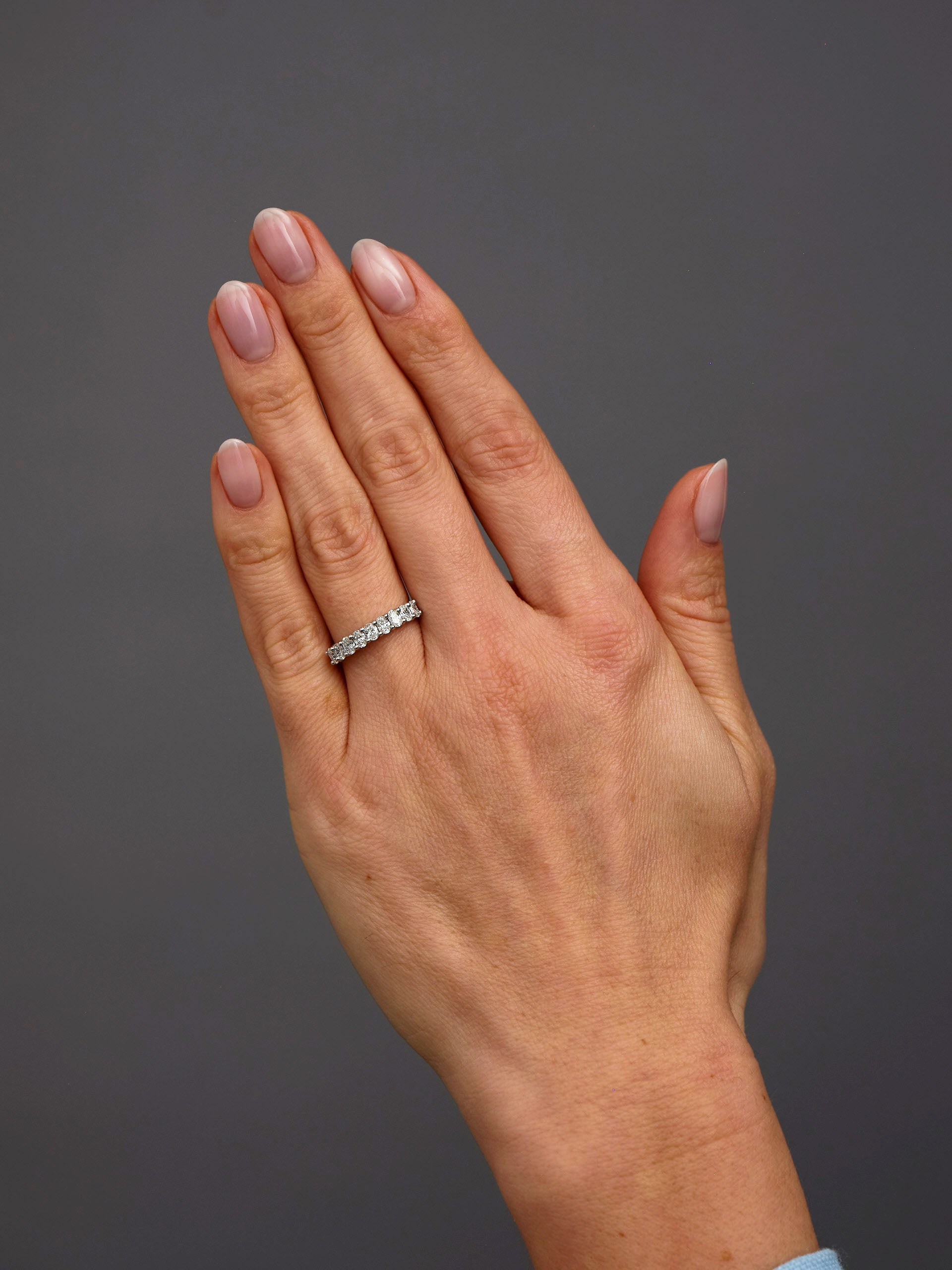 Mini oval diamond engagement bands worn on a finger to show scale and comfort fit.